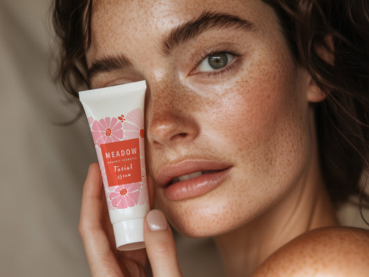 Realistic white cosmetic tube mockup held by a woman with natural glowing skin — perfect for skincare, beauty, or cosmetic packaging presentations.